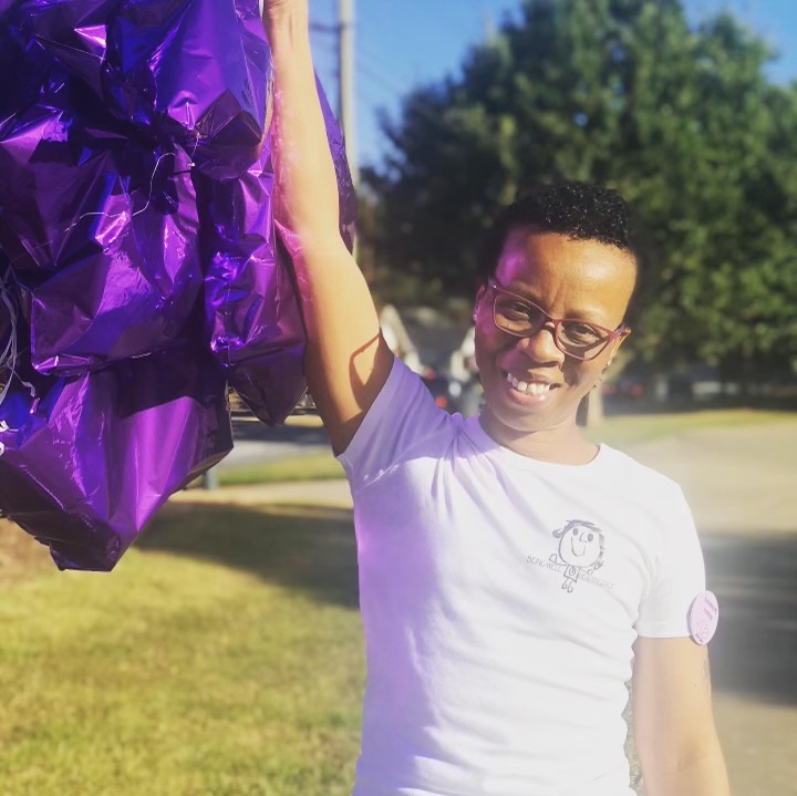 Brejai’s mother smiling in a Moo Moo’s Delights shirt with purple balloons