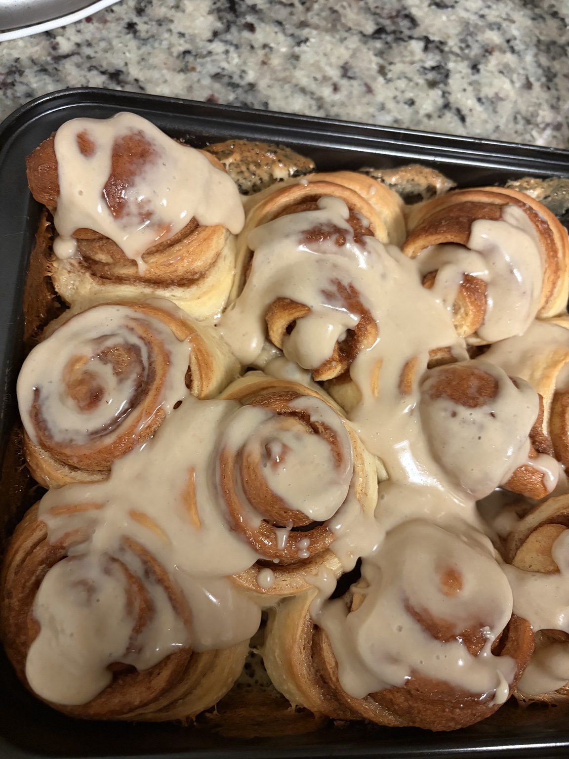 Freshly baked cinnamon rolls topped with icing